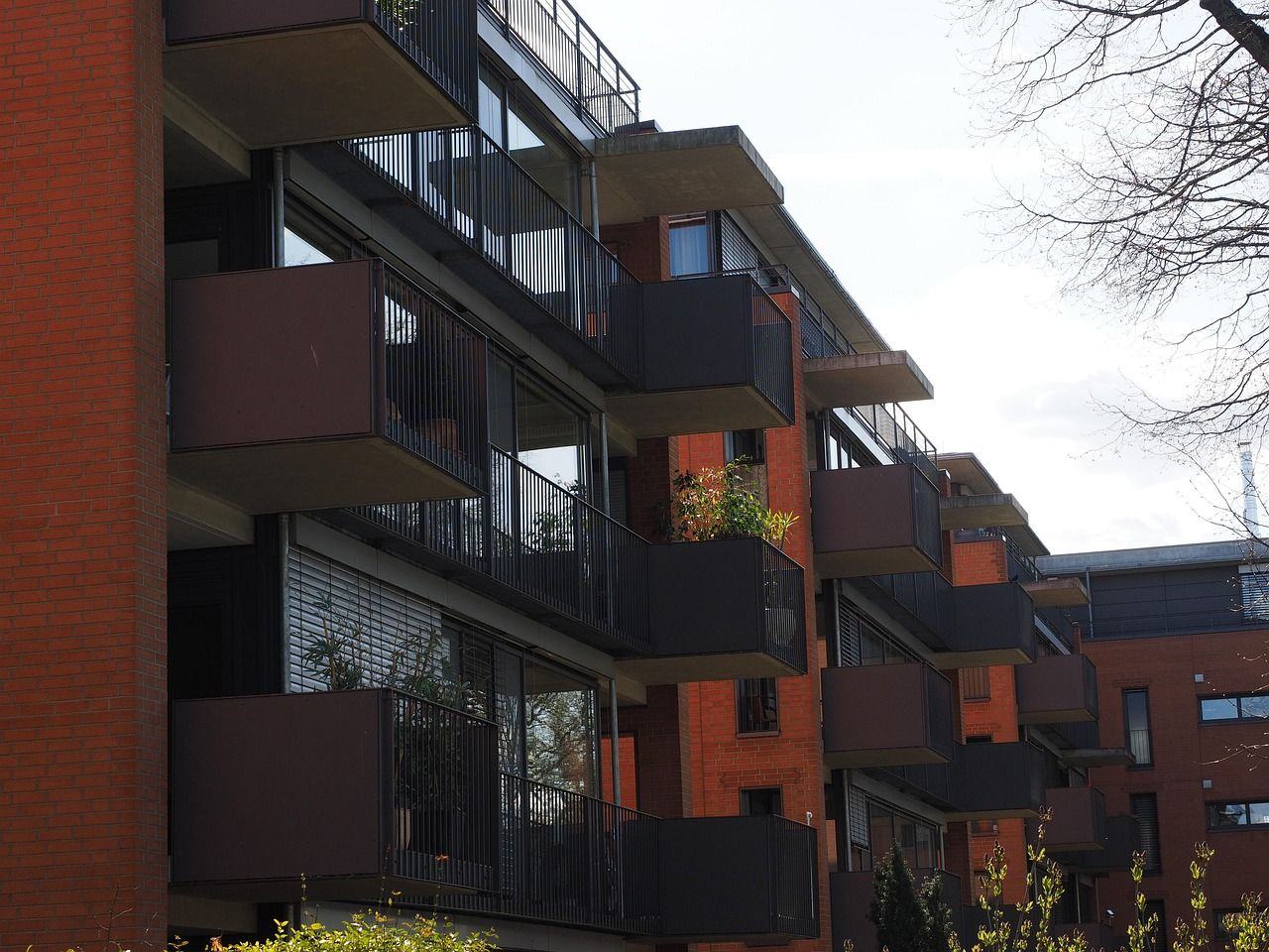 Edificio de viviendas de ladrillo con terrazas, como los bloques de pisos que se alquilan en Fuenlabrada