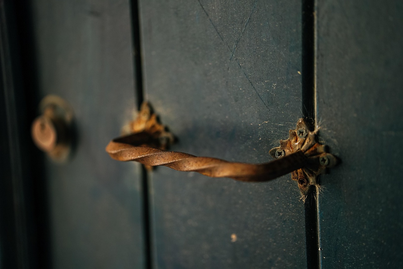 Tirador oxidado de una puerta de madera cerrada, como la de una vivienda alquilada que el propietario quiere recuperar